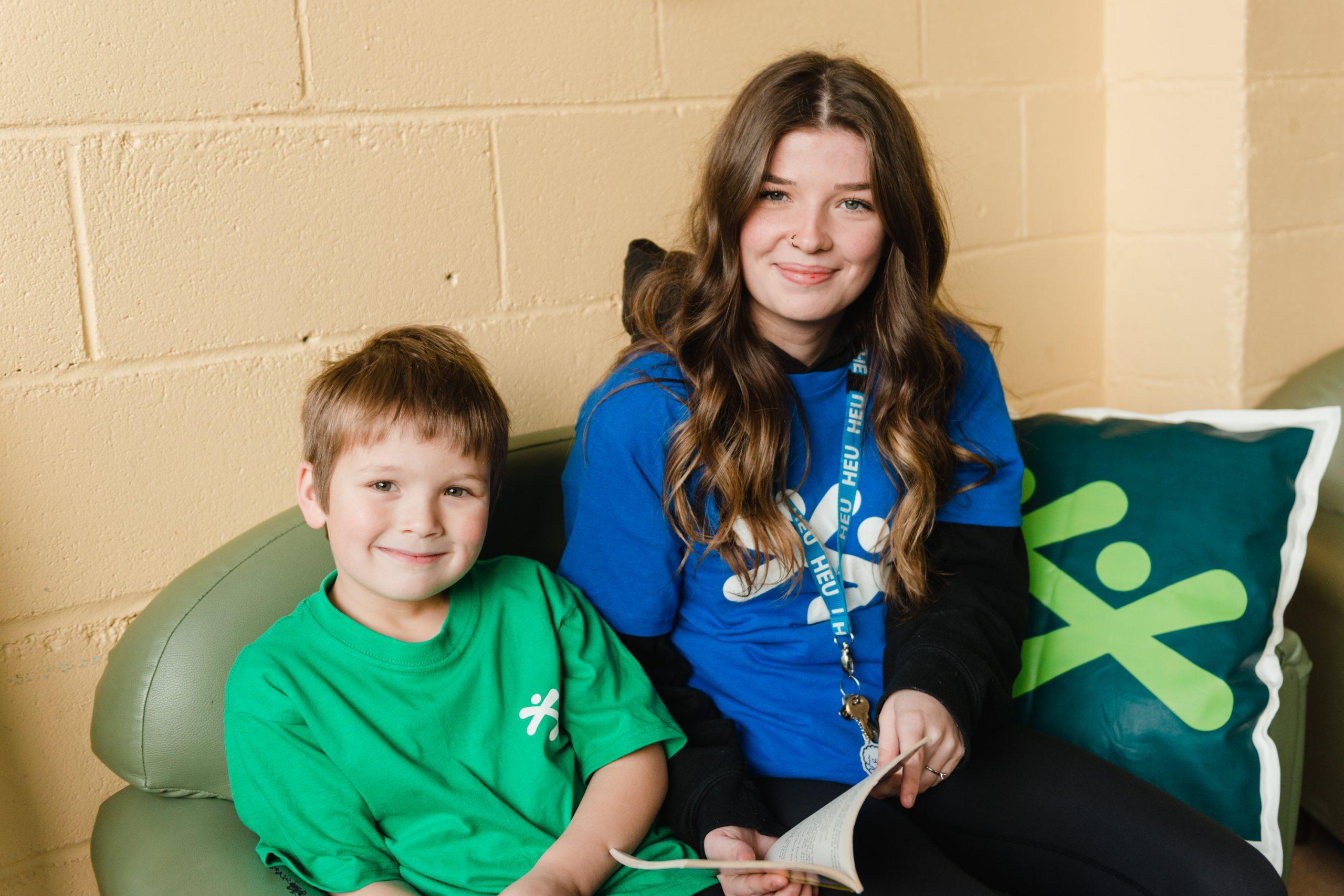 A BGC staff member sitting with a child while reading together.