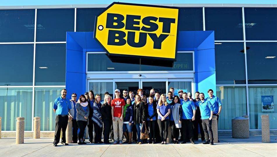 Group of Best Buy employees standing outside a store under the large yellow Best Buy sign