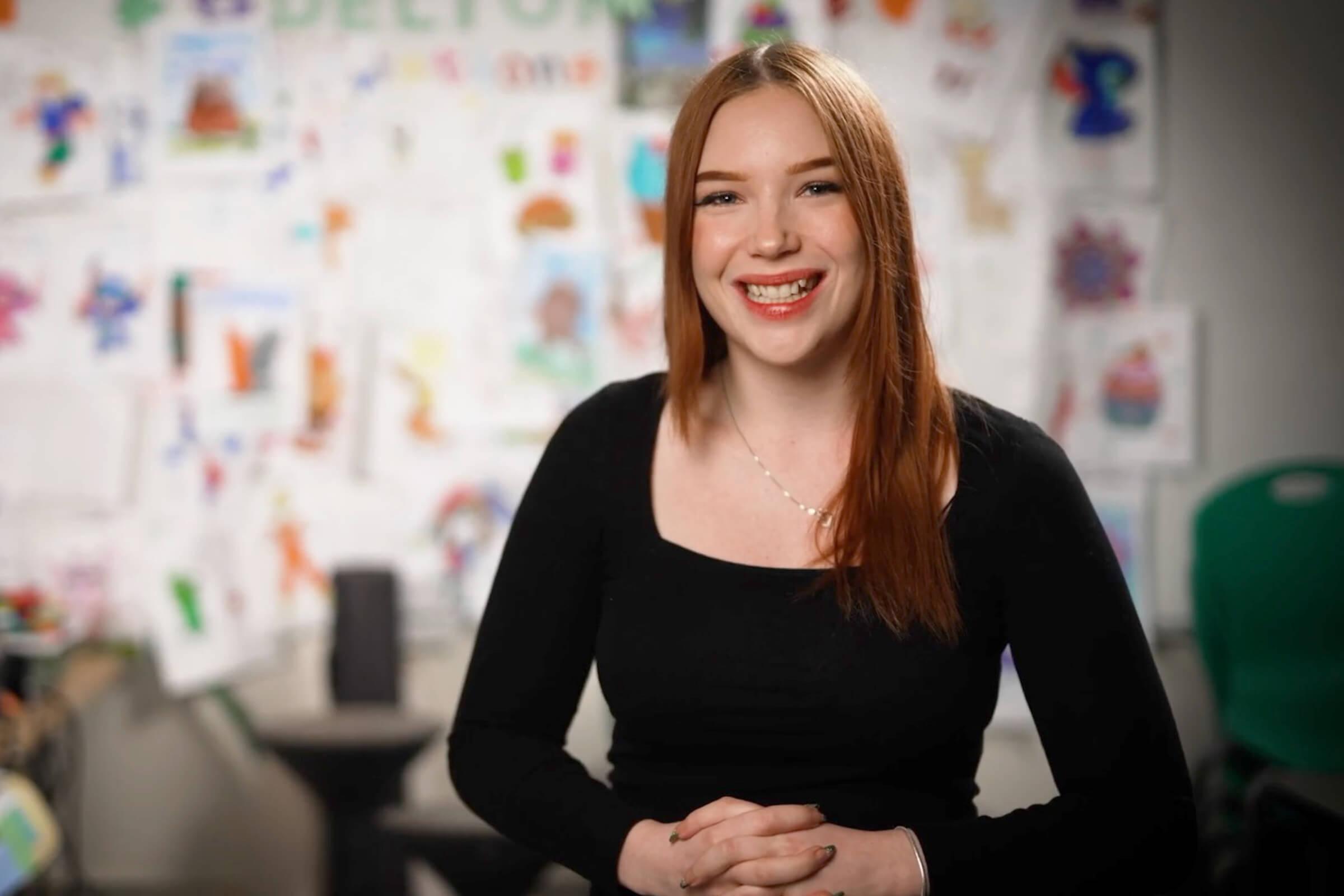 Portrait of Yaël smiling indoors.