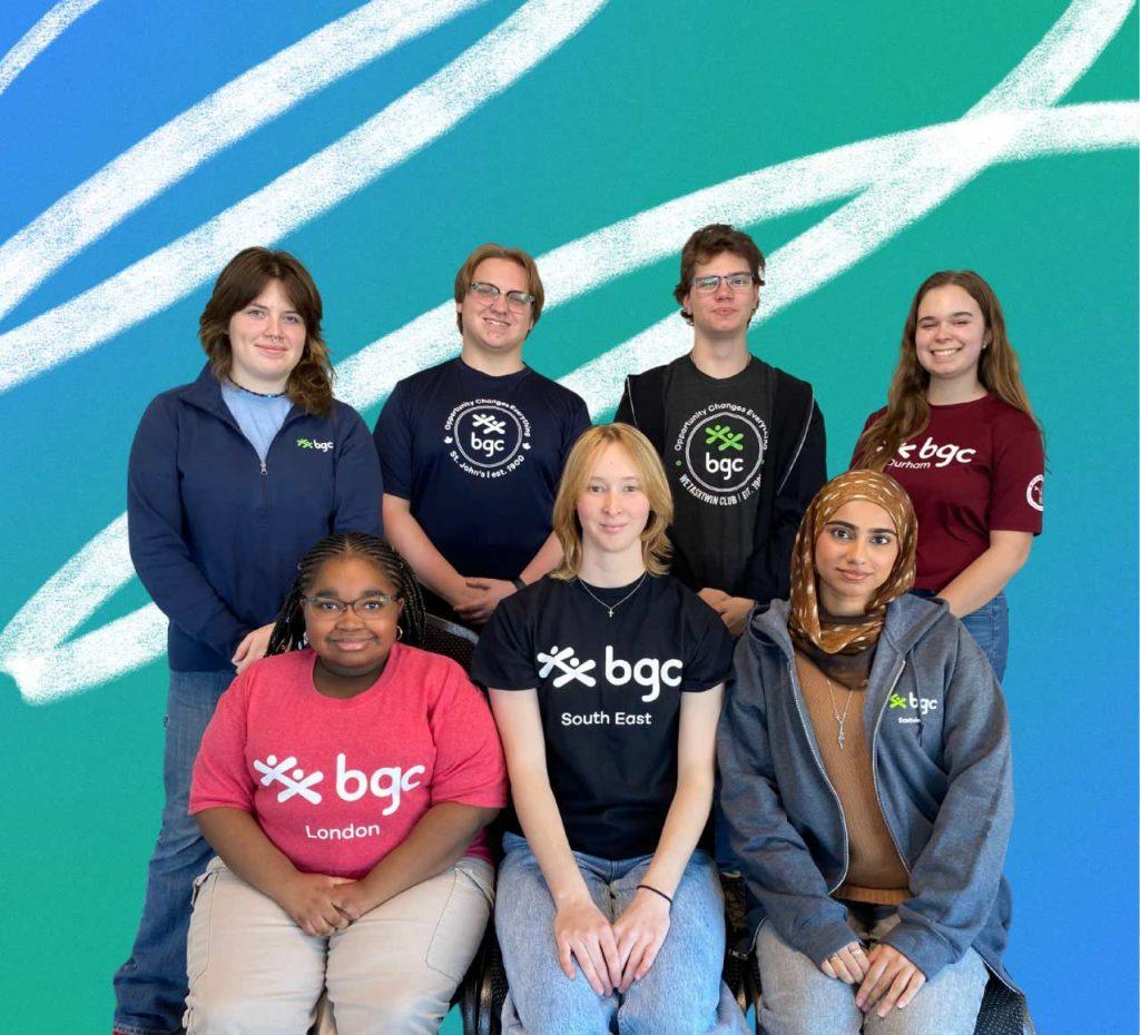 A group of youth standing and sitting together, wearing BGC shirts and smiling in a group portrait.