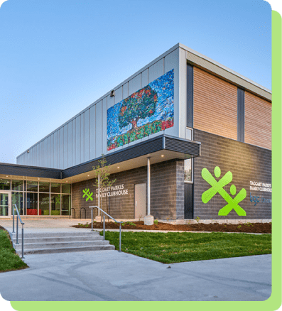 contact-local The modern exterior of the Taggart Parkes Family Clubhouse, featuring a colorful tree mural and green BGC branding.