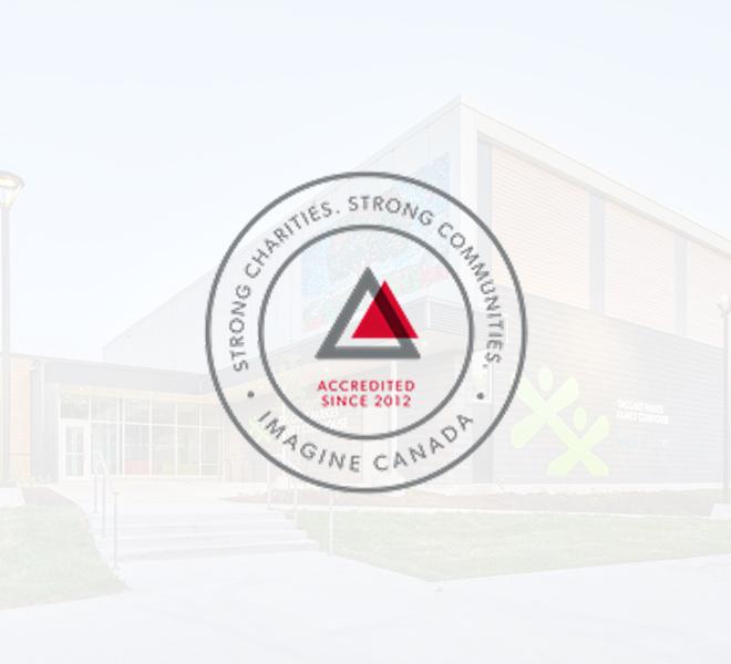 The Imagine Canada accreditation seal, which states "STRONG CHARITIES. STRONG COMMUNITIES." and "ACCREDITED SINCE 2012," is centered over a faded background of the Taggart Parkes Family Clubhouse.