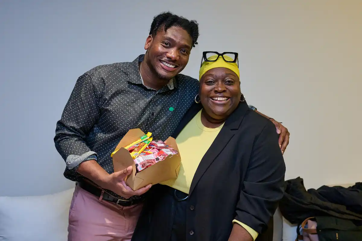 Two people posing together while holding a gift at a BGC event